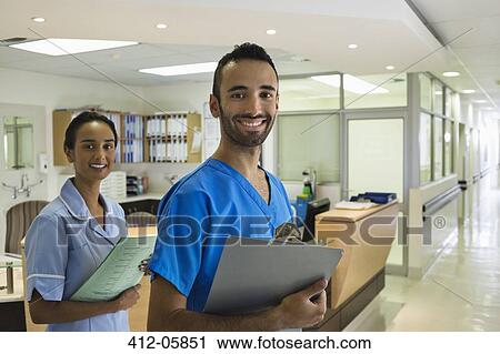 Nurses smiling in hospital hallway View Large Photo Image Stock Image - Nurses smiling in hospital hallway. Fotosearch
