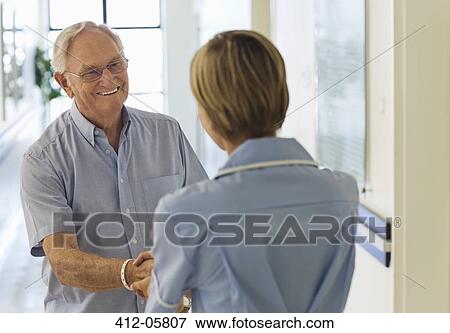 Older patient and nurse shaking hands in hospital View Large Photo Image Stock Photo - Older patient and nurse shaking hands in hospital. Fotosearch