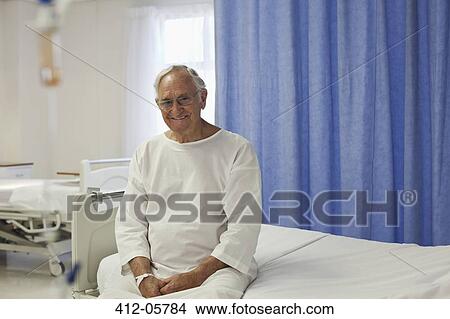 Picture - Older patient sitting on hospital bed. Fotosearch