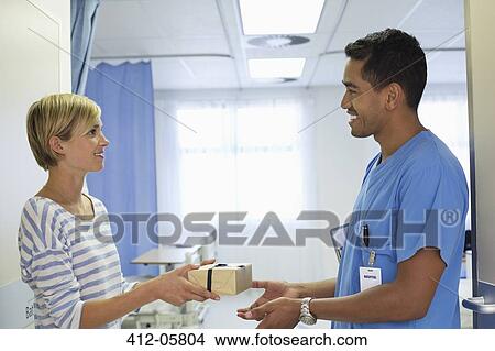 Patient giving nurse gift in hospital View Large Photo Image Picture - Patient giving nurse gift in hospital. Fotosearch