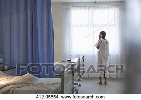 Patient in gown talking on cell phone in hospital room View Large Photo Image Picture - Patient in gown talking on cell phone in hospital room. Fotosearch