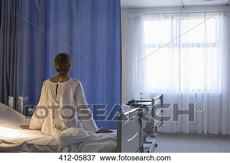 Patient wearing gown on hospital bed View Large Photo Image Stock Photo - Patient wearing gown on hospital bed. Fotosearch