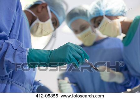 Surgeon holding knife in operating room View Large Photo Image Stock Photography - Surgeon holding knife in operating room. Fotosearch