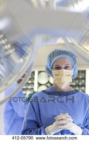 Stock Image - Surgeon standing in operating room. Fotosearch