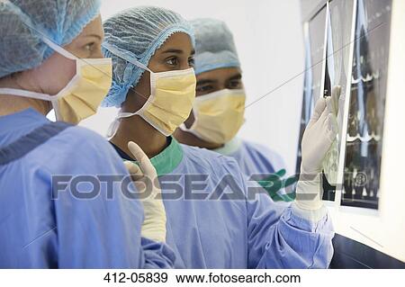 Surgeons examining x-rays in operating room View Large Photo Image Stock Photo - Surgeons examining x-rays in operating room. Fotosearch