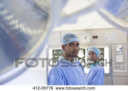 Surgeons standing in operating room View Large Photo Image Stock Photo - Surgeons standing in operating room. Fotosearch