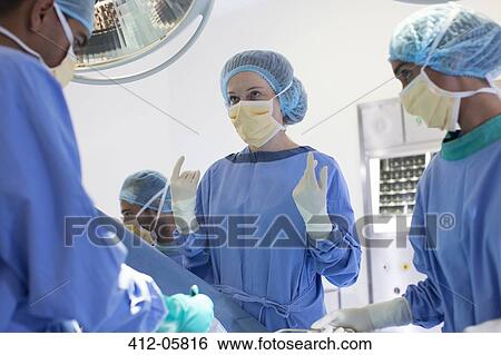 Surgeons talking in operating room View Large Photo Image Stock Photograph - Surgeons talking in operating room. Fotosearch