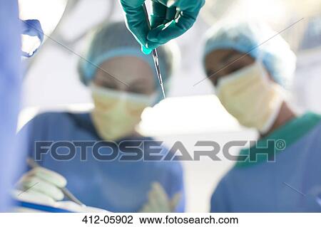 Surgeons working in operating room View Large Photo Image Stock Image - Surgeons working in operating room. Fotosearch