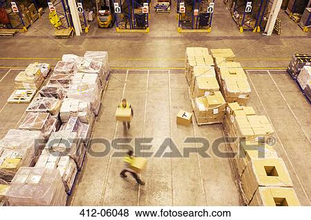 Blurred view of workers carrying boxes in warehouse View Large Photo Image Stock Photo - Blurred view of workers carrying boxes in warehouse. Fotosearch