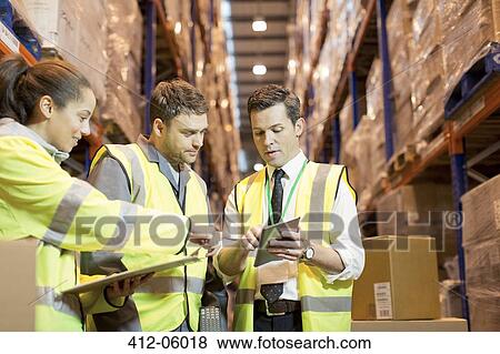 Businessman and workers talking in warehouse View Large Photo Image Stock Photo - Businessman and workers talking in warehouse. Fotosearch