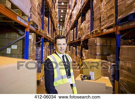 Businessman standing in warehouse View Large Photo Image Picture - Businessman standing in warehouse. Fotosearch