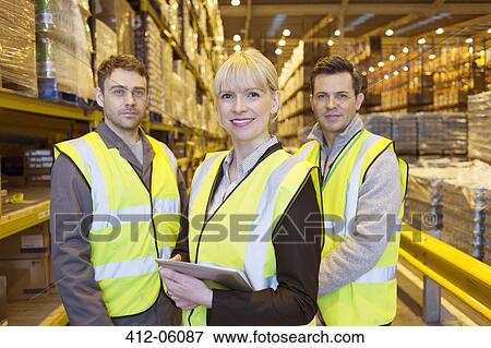 Businesswoman and workers smiling in warehouse View Large Photo Image Stock Photo - Businesswoman and workers smiling in warehouse. Fotosearch