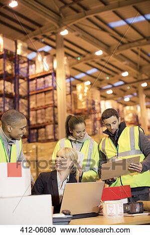 Businesswoman and workers talking in warehouse View Large Photo Image Stock Image - Businesswoman and workers talking in warehouse. Fotosearch