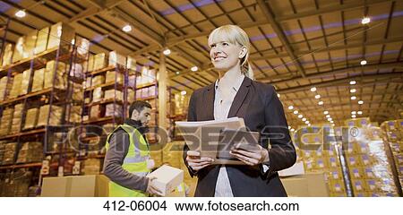 Businesswoman smiling in warehouse View Large Photo Image Picture - Businesswoman smiling in warehouse. Fotosearch