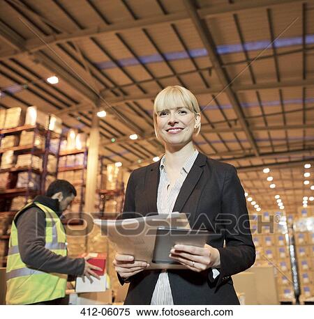 Businesswoman with folder and tablet computer in warehouse View Large Photo Image Stock Photography - Businesswoman with folder and tablet computer in warehouse. Fotosearch