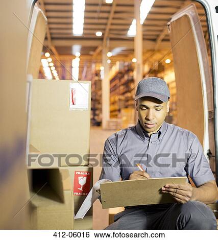 Delivery boy using clipboard in van View Large Photo Image Stock Photograph - Delivery boy using clipboard in van. Fotosearch