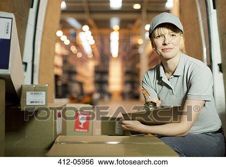 Stock Photograph - Delivery girl checking boxes in van. Fotosearch