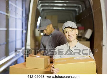 Stock Image - Delivery people loading boxes into van. Fotosearch