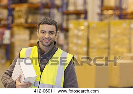 Worker carrying box in warehouse View Large Photo Image Stock Image - Worker carrying box in warehouse. Fotosearch