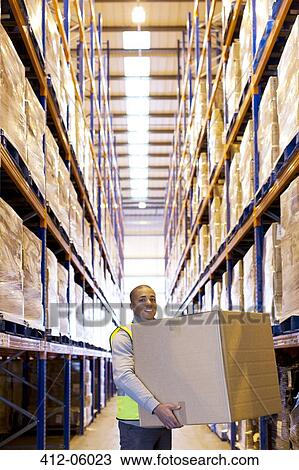 Worker carrying box in warehouse View Large Photo Image Stock Image - Worker carrying box in warehouse. Fotosearch