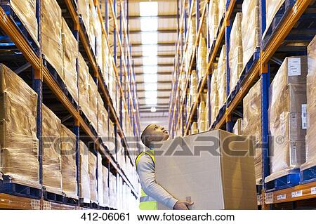 Worker carrying box in warehouse View Large Photo Image Stock Image - Worker carrying box in warehouse. Fotosearch