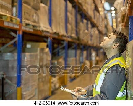 Worker checking boxes in warehouse View Large Photo Image Picture - Worker checking boxes in warehouse. Fotosearch