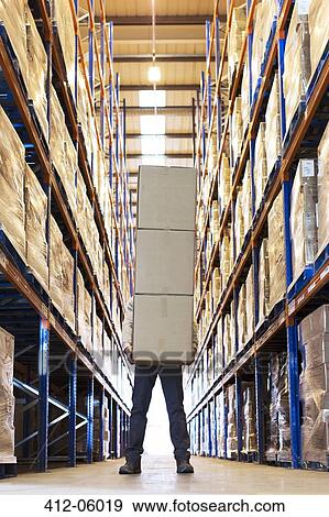 Stock Photo - Worker holding boxes in warehouse. Fotosearch