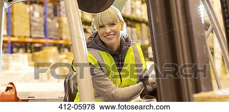 Stock Photo - Worker operating forklift in warehouse. Fotosearch