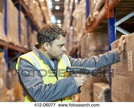 Stock Photo - Worker scanning boxes in warehouse. Fotosearch