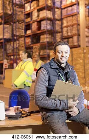 Worker smiling in warehouse View Large Photo Image Stock Image - Worker smiling in warehouse. Fotosearch