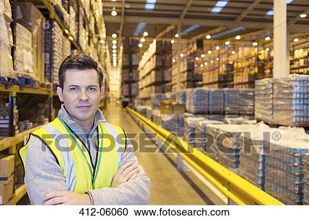 Stock Image - Worker smiling in warehouse. Fotosearch