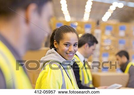 Stock Photo - Worker smiling in warehouse. Fotosearch