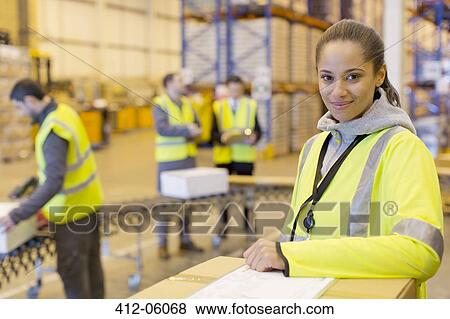 Worker smiling in warehouse View Large Photo Image Stock Photo - Worker smiling in warehouse. Fotosearch