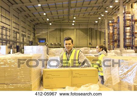 Worker unpacking boxes in warehouse View Large Photo Image Stock Photo - Worker unpacking boxes in warehouse. Fotosearch