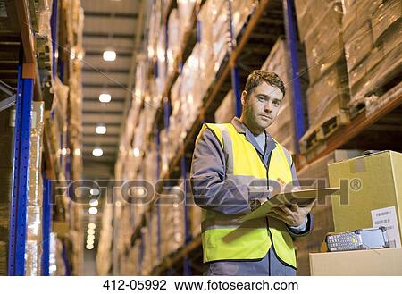 Worker writing on clipboard in warehouse View Large Photo Image Stock Image - Worker writing on clipboard in warehouse. Fotosearch