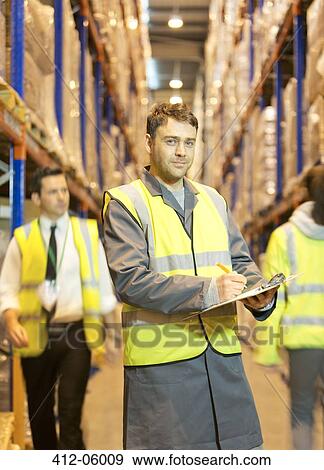 Worker writing on clipboard in warehouse View Large Photo Image Stock Photo - Worker writing on clipboard in warehouse. Fotosearch