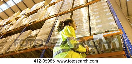 Worker writing on clipboard in warehouse View Large Photo Image Stock Photography - Worker writing on clipboard in warehouse. Fotosearch