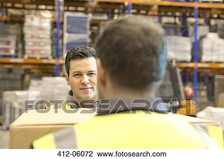 Workers carrying box in warehouse View Large Photo Image Stock Image - Workers carrying box in warehouse. Fotosearch