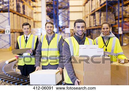 Workers smiling by conveyor belt in warehouse View Large Photo Image Stock Image - Workers smiling by conveyor belt in warehouse. Fotosearch