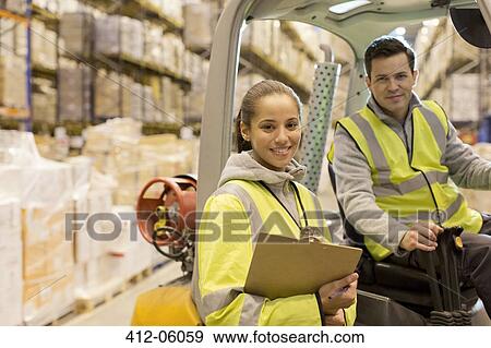 Stock Photo - Workers smiling in warehouse. Fotosearch