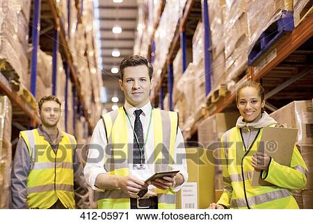Stock Image - Workers standing in warehouse. Fotosearch