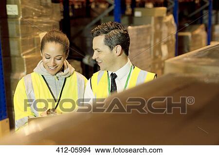 Picture - Workers talking in warehouse. Fotosearch