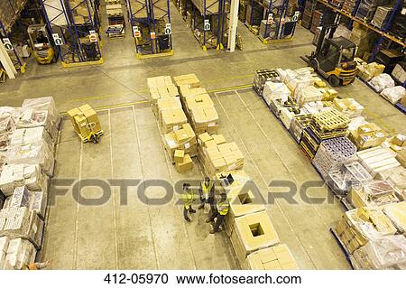 Stock Image - Workers talking in warehouse. Fotosearch
