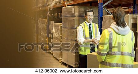 Stock Image - Workers talking in warehouse. Fotosearch