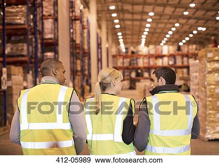 Workers talking in warehouse View Large Photo Image Stock Photo - Workers talking in warehouse. Fotosearch