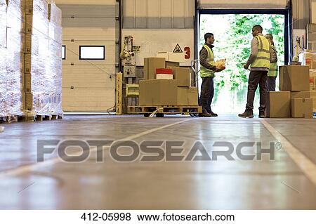 Stock Photo - Workers talking in warehouse. Fotosearch