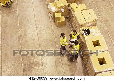 Stock Photo - Workers talking in warehouse. Fotosearch
