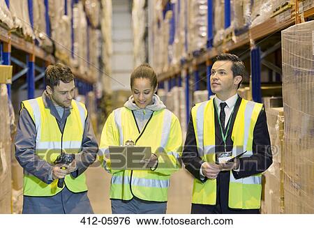 Stock Photograph - Workers talking in warehouse. Fotosearch