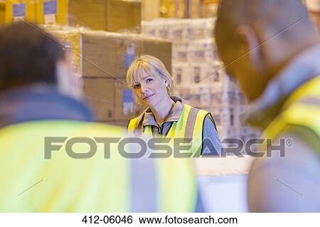 Workers talking in warehouse View Large Photo Image Stock Photograph - Workers talking in warehouse. Fotosearch