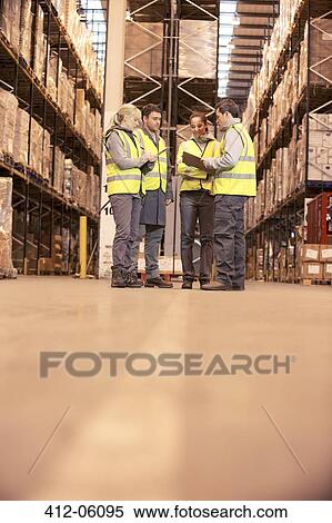 Stock Photography - Workers talking in warehouse. Fotosearch